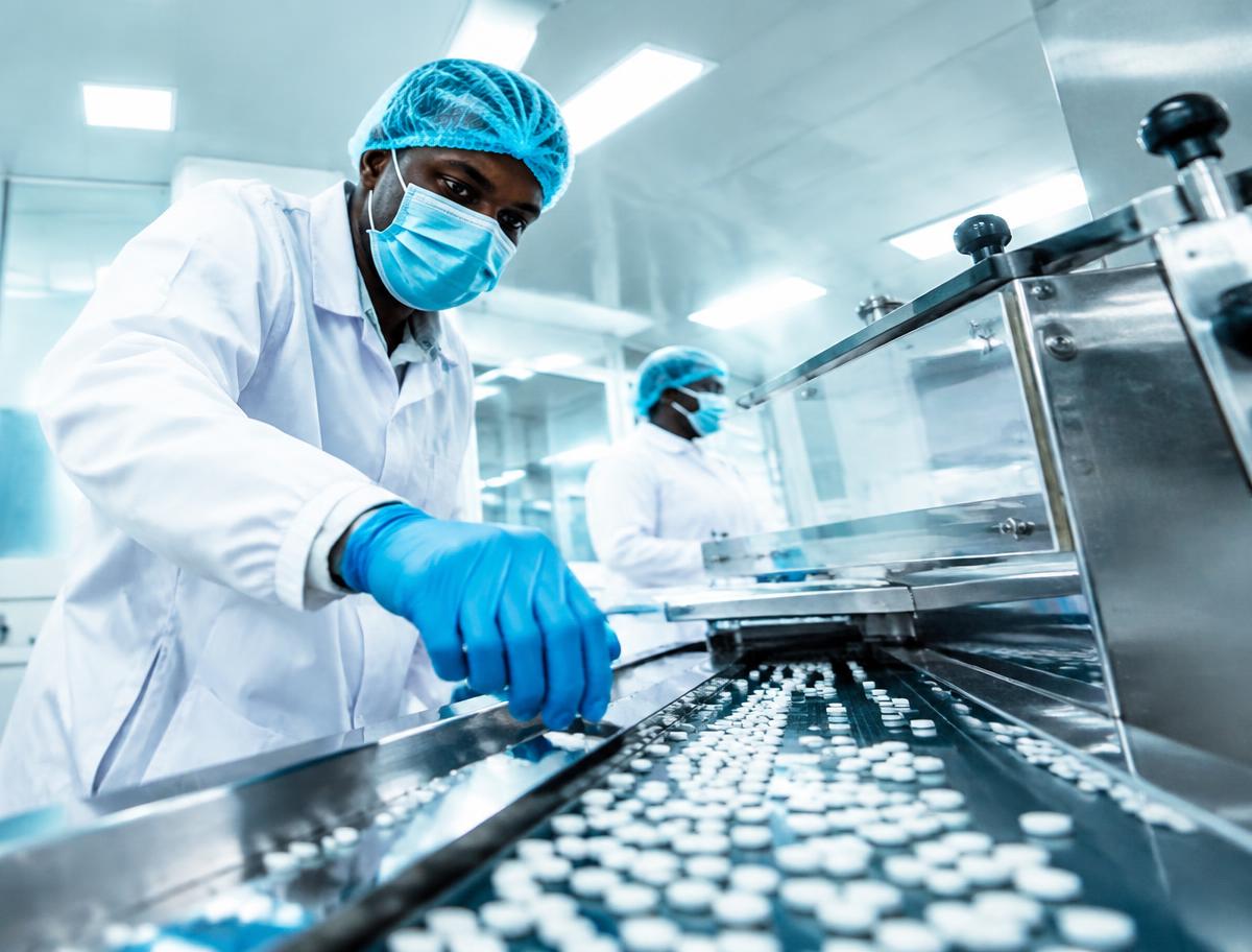Pharmaceutical production line with workers in protective gear